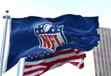 NFL flag waving beside American flag.