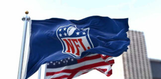 NFL flag waving beside American flag.