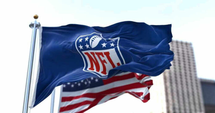 NFL flag waving beside American flag.
