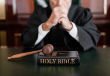 A judge in a courtroom with a gavel and a Holy Bible on the table
