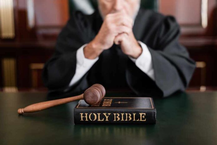 A judge in a courtroom with a gavel and a Holy Bible on the table