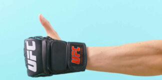 Thumbs up with UFC gloves, blue background.