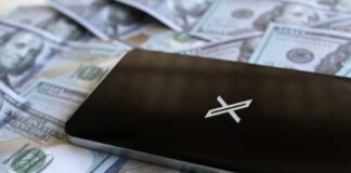 A smartphone placed on a pile of hundred-dollar bills