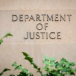 Sign displaying 'Department of Justice' on a stone wall