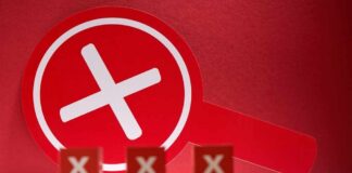 A red magnifying glass with a cross symbol against a red background