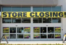 Storefront with a large 'STORE CLOSING' banner and sale signs
