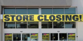 Storefront with a large 'STORE CLOSING' banner and sale signs