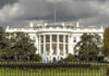 The White House with dark clouds overhead.