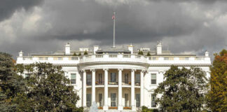 The White House with dark clouds overhead.