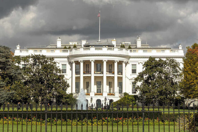 The White House with dark clouds overhead.