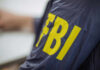 Person wearing FBI jacket, letters in yellow.