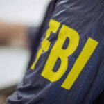 FBI Director Drops $250M Lawsuit Bomb Person wearing FBI jacket, letters in yellow.