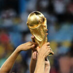 FIFA’s Halftime Shock: Tradition Shattered Hands holding the FIFA World Cup trophy aloft in celebration