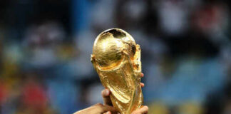 Hands holding the FIFA World Cup trophy aloft in celebration