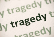 Close-up of the word 'tragedy' printed multiple times in varying shades