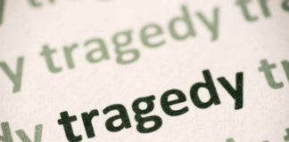 Close-up of the word 'tragedy' printed multiple times in varying shades