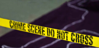 Yellow crime scene tape marking off an area with a chalk outline