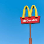 McDonald’s KILLING Beloved Feature McDonald's restaurant sign against a clear blue sky