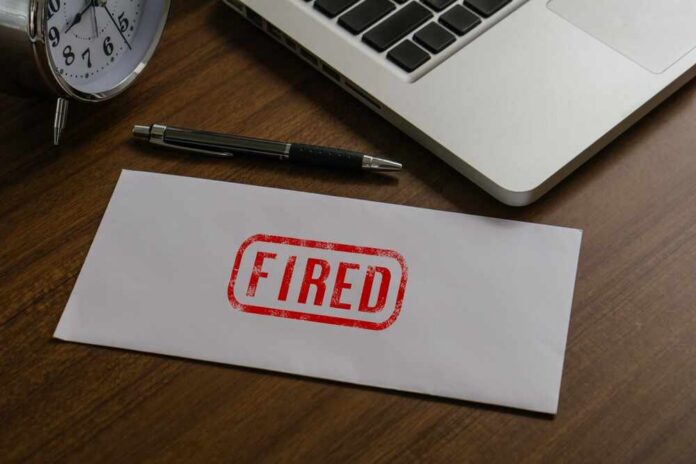 Fired,Text,On,Paper,Envelope,To,Dismiss,The,Employee.fired,Jobs An envelope marked 'FIRED' on a wooden desk next to a clock and a laptop
