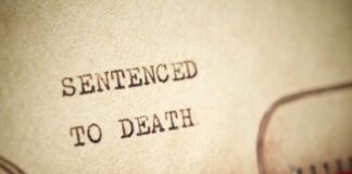 Close-up of a typewritten document stating 'SENTENCED TO DEATH'