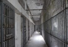 Injection Kills Star — Assistant Sentenced! Empty prison corridor with barred cells on either side