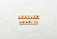 Wooden letter tiles spelling 'Product recall' on a textured surface