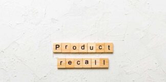 Wooden letter tiles spelling 'Product recall' on a textured surface
