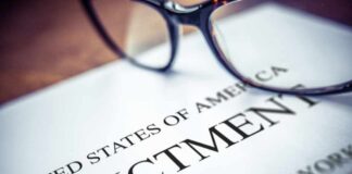 Close-up of an indictment document with glasses resting on it