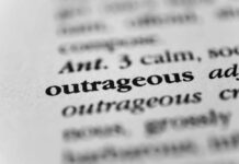 Election Denier’s Sentence Halved – Outrage Erupts! Close-up of a dictionary entry highlighting the word 'outrageous'