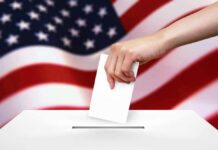 Voting Map UPROAR: Will It Impact You? Hand dropping ballot into box, American flag background.
