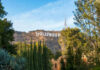 Hollywood sign on hills, surrounded by trees.