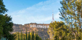 Hollywood sign on hills, surrounded by trees.