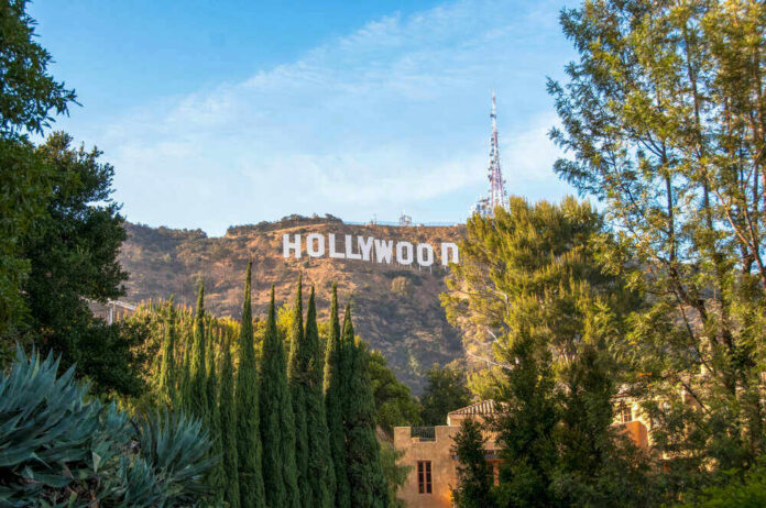Hollywood sign on hills, surrounded by trees.