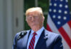 Shock Trump Pick Stuns Leftists Donald Trump speaking with US flag in the back.
