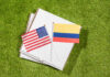 USA and Colombia flags on pizza boxes on grass