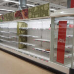 Empty supermarket shelves with great prices signage