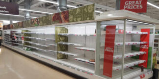 Empty supermarket shelves with great prices signage