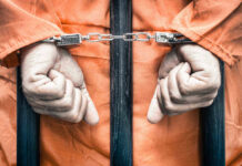 Judge Slams Brakes: Teen Locked Up Handcuffed person in orange jumpsuit behind prison bars.