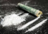 Cocaine lines with rolled banknote on surface
