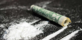 Cocaine lines with rolled banknote on surface