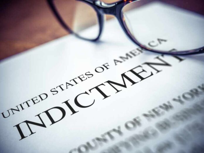 An,Indictment,Document,On,A,Desk,,With,Glasses,And,Shallow Close-up of an indictment document with glasses resting on it