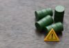 Oil Panic VANISHES — Investors Cheer Four green barrels and a warning sign on a wooden surface