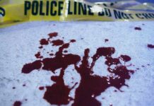 Weekend Bloodbath Leaves 6 Dead Blood stains on a surface with police caution tape in the background