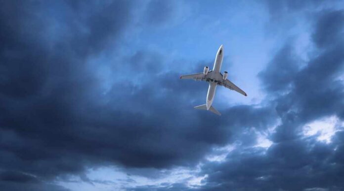 Passenger,Plane,Flying,In,A,Twilight,,Stormy,Sky.,Aviation,And An airplane flying through a cloudy sky