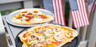 Homemade pizzas on grill trays with vegetable and pepperoni toppings