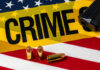 Midnight Drive-By Shooting Rips Neighborhood Park A gun and bullets on an American flag with a crime scene marker