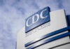 CDC building sign against a cloudy sky.