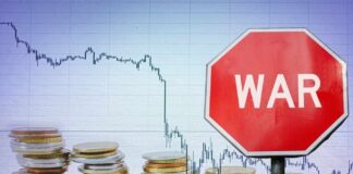 A stop sign with the word 'WAR' in front of a declining stock market graph and stacks of coins