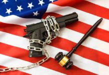 Gun Rights On The Brink A handgun chained on an American flag with a gavel beside it
