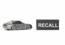 Seats Flip Mid-Drive — Big Recall A miniature gray sports car next to a black sign that reads 'RECALL'
